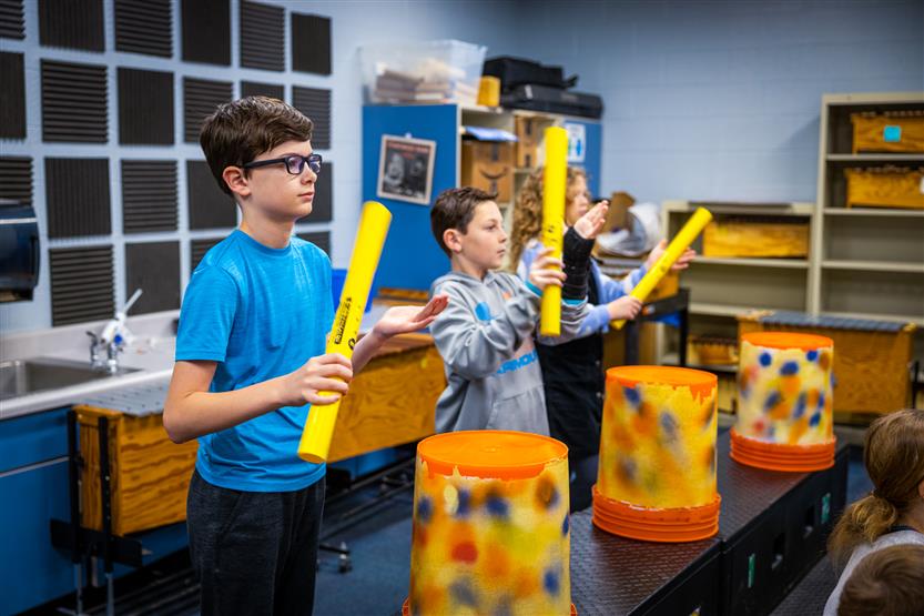 Students play drums in music class